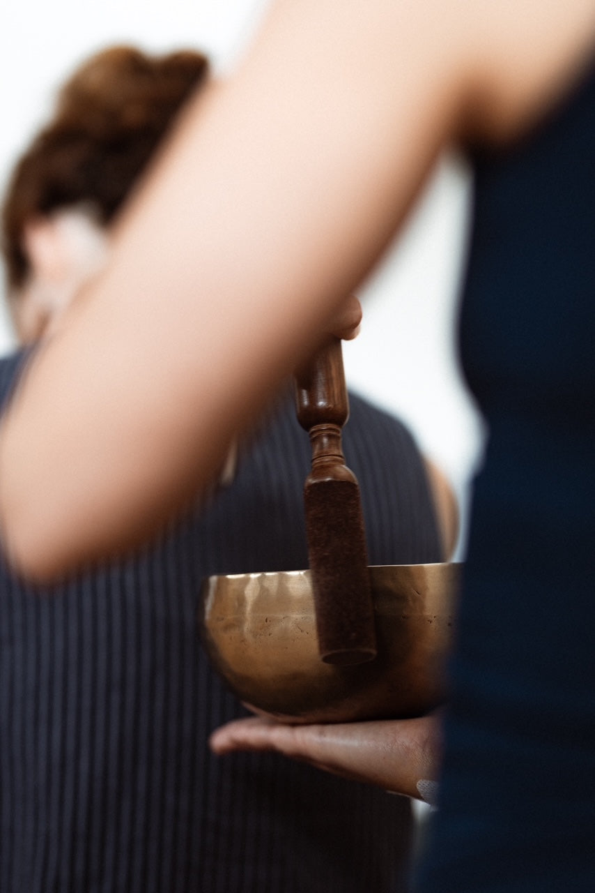 Fanny Guiraud, professeure de yoga et sonothérapeute, entrain de frapper un bol tibétain
